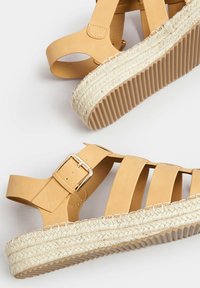 Sandali in pelle marrone chiaro con design a fasce, chiusura con fibbia e suola in juta stile espadrille con base in gomma testurizzata.