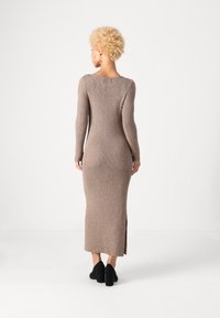 Ribakudumisest beetž dress, pikkade varrukatega, ümmargune kaelus, külgslitsid, keha lähedane siluett, kombineeritud mustade kontsakingadega.