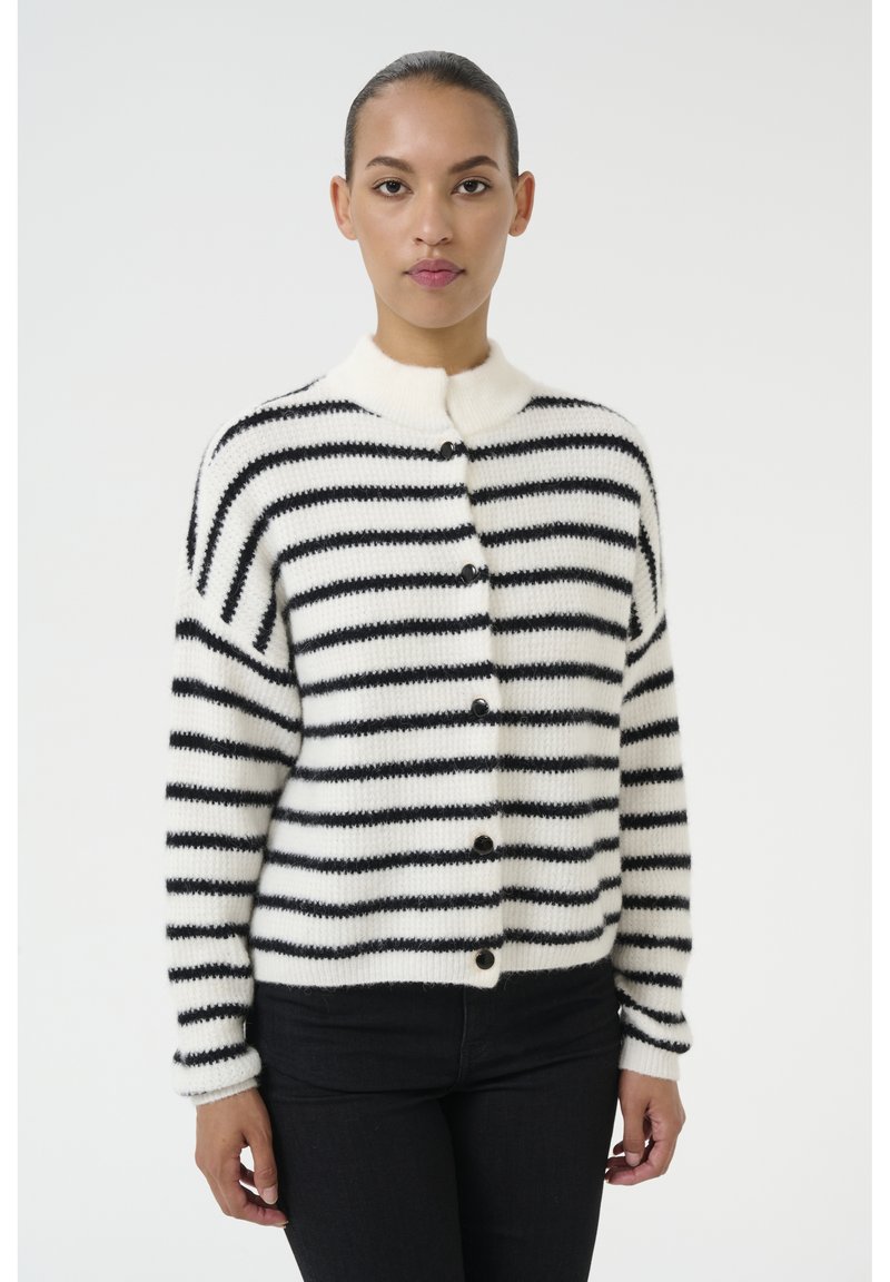 Cardigan a righe in bianco e nero, con colletto alto, chiusura a bottoni e texture a coste. Materiale in maglia morbido con vestibilità ampia.