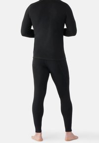 Sort langærmet basislag top og leggings med en glat overflade, tætsiddende design og flade sømme for komfort.