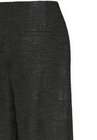 Pantaloni neri con texture a motivo intrecciato, tasca laterale discreta e leggero scintillio su tutto il tessuto.