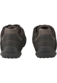 Sneakers GEOX z ciemno-brązową cholewką z zamszu i skóry, z wyściełanym kołnierzem oraz gumową podeszwą z małymi wypustkami trakcyjnymi.