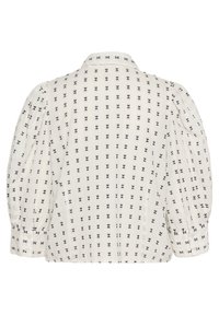 Chemisier blanc à manches bouffantes, avec un motif quadrillé de petits nœuds noirs. Des détails de poignets boutonnés et un col classique complètent le design.