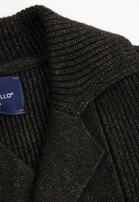 Ciemnoszary, dzianinowy kardigan o prążkowanej fakturze, z szerokim kołnierzem i niebieską metką wszytą w środku.