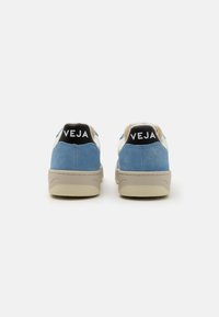 Blue suede and white leather sneakers with beige rubber soles. Black heel accent features "VEJA" in bold white letters.
