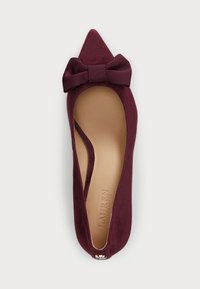 Burgundy suede flat shoe with a pointed toe and a large bow accent. Features a cutout design and a smooth beige insole.