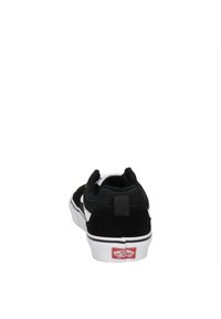 Sneaker bianco e nero con tacco in suede testurizzato, linguetta in mesh, suola in gomma bianca e logo Vans rosso sul tallone.