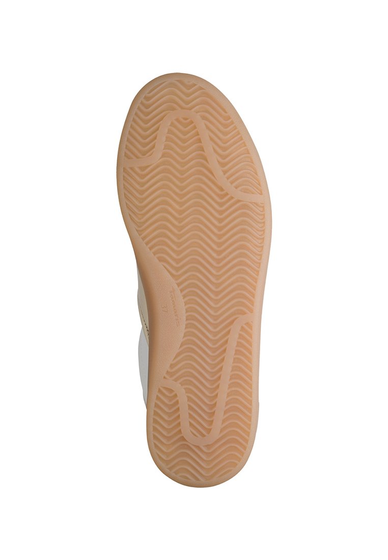 Podeszwa buta z falistym wzorem, wykonana z gumy w jasnym odcieniu brązu. Okrągły kształt definiuje styl sneakersów.