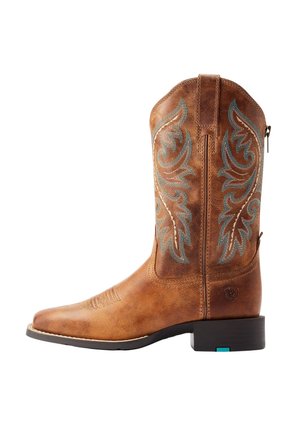 Bota de vaquero de cuero marrón con patrones de llamas bordadas en azul y beige y un tacón negro bajo sobre un fondo blanco.