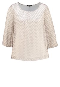 Blouse beige clair avec un motif floral texturé, encolure ronde et manches trois-quarts, dotée d'une coupe décontractée et d'un tissu lisse.