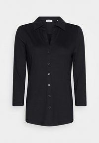 Chemise noire à col, à manches longues, dotée d'une fermeture à bouton à l'avant et d'une texture lisse. Design simple sans motifs ni accents supplémentaires.