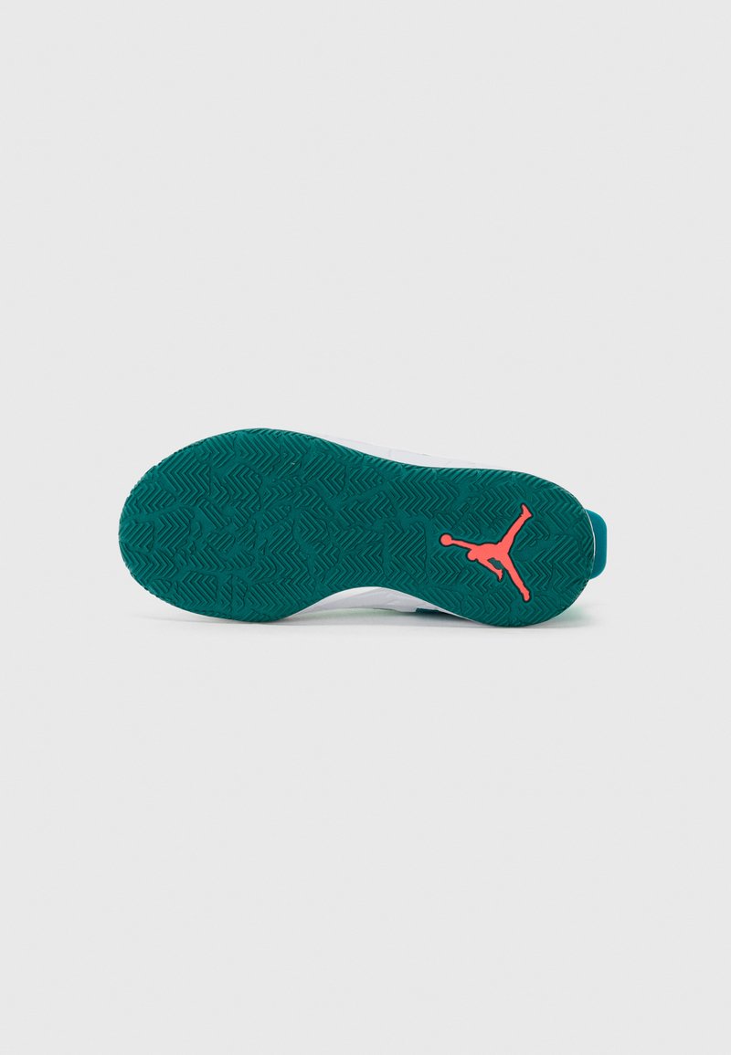 La semelle de la chaussure présente un matériau en caoutchouc vert avec un motif de bande de roulement en zigzag et un logo Jumpman orange bien en évidence.