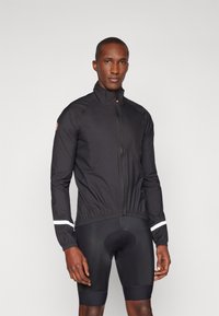 Schwarze Radjacke mit hohem Kragen, Frontreißverschluss und elastischem Saum. Verfügt über weiße Akzente an den Ärmeln. Leicht und körpernah geschnitten.
