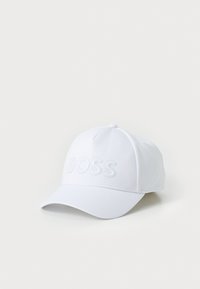 Hvit baseballcaps laget av teksturert stoff med et preget "BOSS"-logo foran og en buet skjerm.