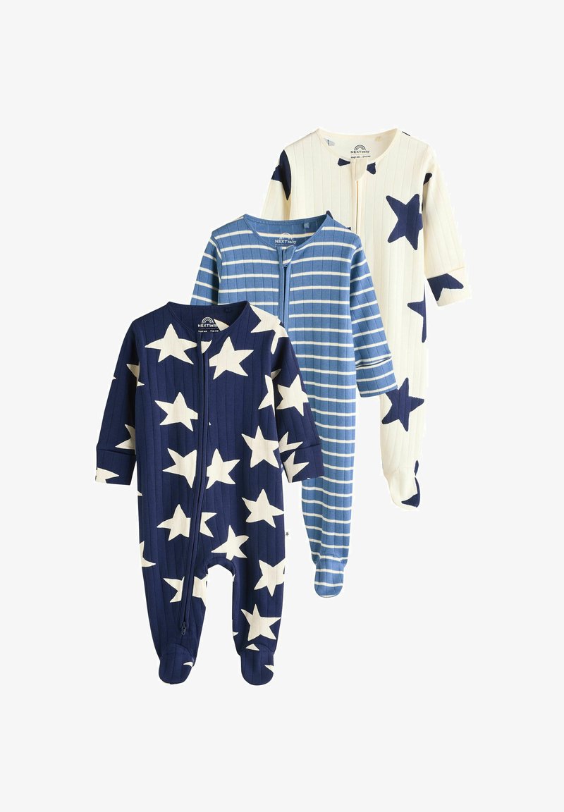Three children’s onesies: one navy with white stars, one blue striped, and one cream with navy stars; all feature long sleeves and zip closures.