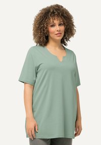 Top verde menta a maniche corte con scollatura a v e vestibilità morbida. Tessuto liscio e leggero con una leggera elasticità.