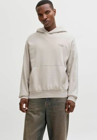 Hele hall kapuutsiga jakk, tehtud pehmest kangast, ees tasku ja paelaga kapuutsiga. Kandmiseks koos lahtiste teksadega, nähtav minimaalne bränding.