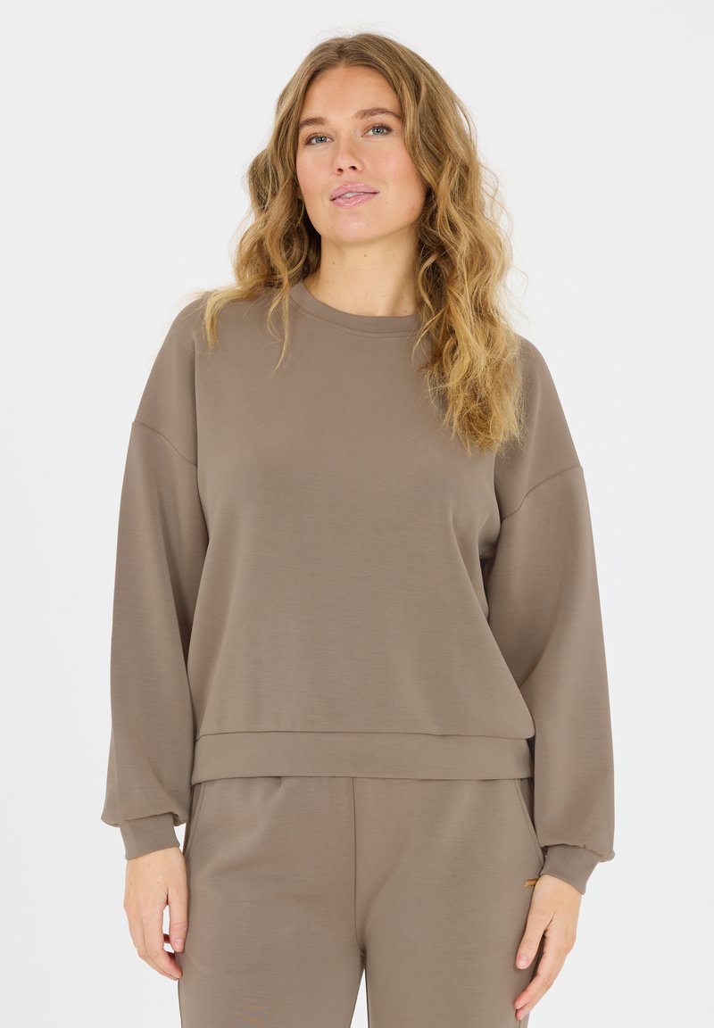 Bruine sweatshirt met lange mouwen, een ronde hals, een relaxte pasvorm, ribgebreide manchetten en een gladde textuur, gecombineerd met bijpassende broek, wat eenvoud uitstraalt.
