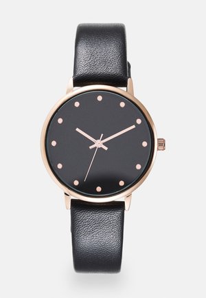 Schwarze Lederarmbanduhr mit schwarzem Zifferblatt, Roségoldgehäuse, minimalistischen Punkt-Stundenmarkierungen und drei schlanken Zeigern, die 10:10:36 anzeigen.