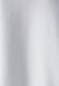 Tessuto bianco con una superficie liscia e morbida, dall'aspetto uniforme, caratterizzato da una leggera lucentezza e privo di pattern o dettagli visibili.