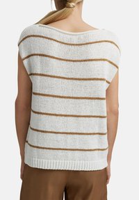 Valkoinen neulottu yläosa, jossa on leveä pääntie ja lyhyet hihat. Yläosassa on vaakasuoria ruskeita raitoja. Resorireuna ja väljä istuvuus.