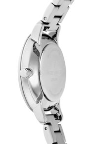 Reloj de acero inoxidable con acabado pulido, caja redonda y pulsera de metal plateado. Presenta una corona y texto grabado en la parte posterior de la caja.