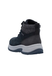 Dunkelblaue Wildlederstiefel mit einem strukturierten grauen Stoffkragen, ausgestattet mit einer weißen Zwischensohle und einer Gummisohle mit einem gemusterten Profil.