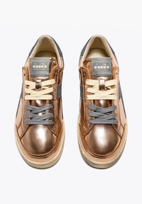 Sneakers in pelle marrone con accenti metallici, lati in suede grigi, lacci beige e un'etichetta in tessuto testurizzato sulla linguetta. Suole in gomma con una finitura usurata.