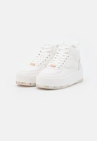 Białe sneakersy z platformą, z wytłoczonym wzorem. Wykonane z gładkiego materiału syntetycznego, z zapięciem na sznurowadła i przeszywanymi akcentami.