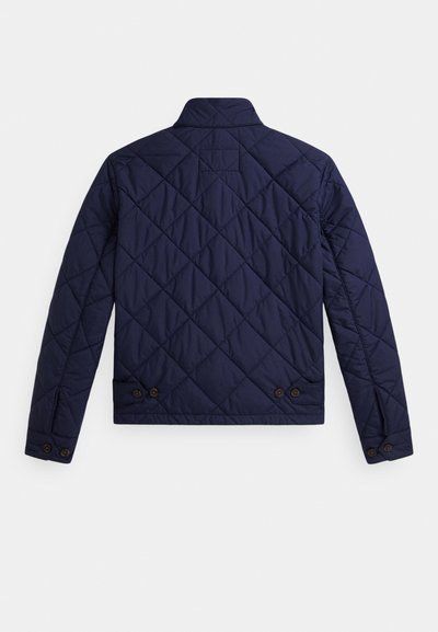 Tumši zila izšūta jaka ar dimanta dizaina šuvēm, pogām aiztaisāmām aprocēm un regulējamām pogu cilpām apakšējā muguras daļā, redzama no aizmugures.