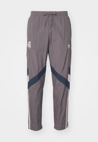 Pantalones deportivos grises fabricados con material ligero, con cintura ajustable por cuerda, que presentan rayas diagonales en blanco y azul marino y acentos de logo.