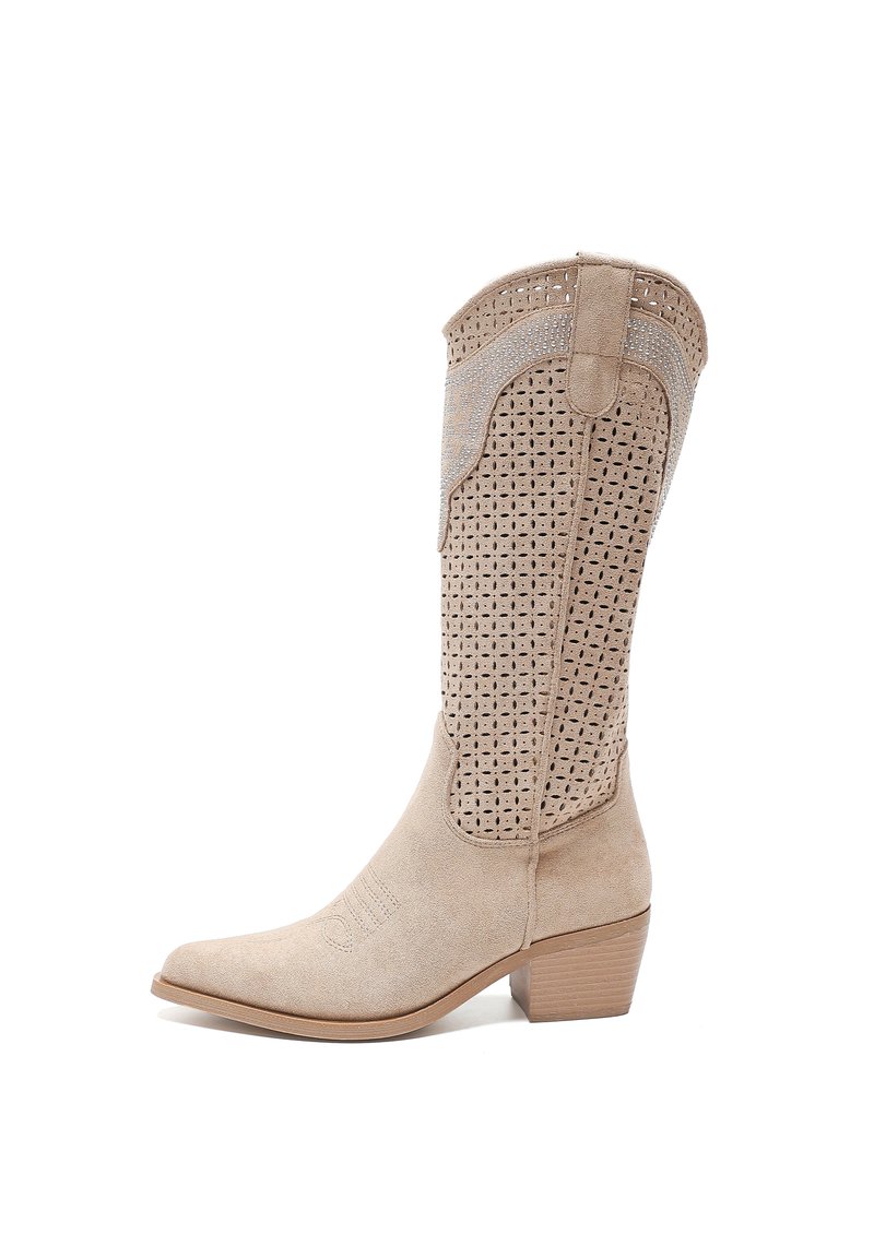 Bota de vaquero de ante beige con parte superior perforada, punta afilada y tacón apilado. La costura decorativa a lo largo de los laterales añade detalle.