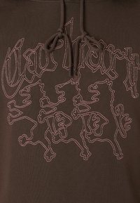 Felpa marrone con una consistenza morbida, caratterizzata da un design di due leoni contornati da cuciture rosa in contrasto. Include un cappuccio con cordino.
