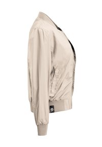 Helle beigefarbene Bomberjacke mit Reißverschluss vorne, geripptem Kragen und Ärmeln, seitlichen Taschen und einem Logosticker am Saum.