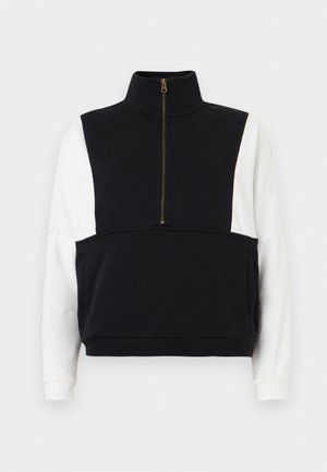 Pull-over à manches longues noir et blanc avec fermeture éclair à moitié sur le devant, col haut et deux poches avant.