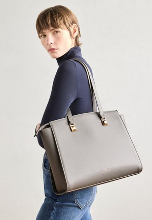 Šedá kožená taška typu tote so zlatými kovovými doplnkami. Štruktúrovaný tvar, dvojité uchá, textúrovaný povrch a značkový detail na prednej strane.