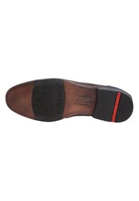 Brown leather shoe sole with a textured black rubber section, curved shape, and a red accent on the heel. Stitched detailing on the sides.