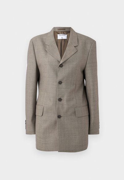 Brun rutig blazer med en enkelknäppt design, snedskurna slag, fem knappar och två framfickor. Slät textur med skräddarsydd passform.