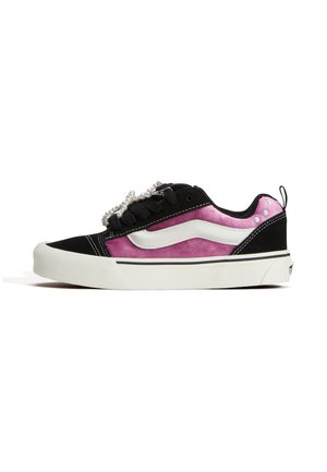 Låg sneaker med rosa sametssidor, svart mockatå och häl, vit vågformad rand, pärlfärgade skosnören och vit gummisula.