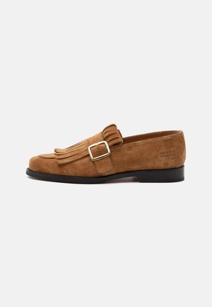 Brun herre loafer i ruskind med spænde i guld, frynse-detaljer på toppen, sort sål og præget mærkenavn på hæl-siden.