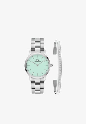 Reloj de acero inoxidable plateado con una esfera verde menta y acabado pulido. Presenta marcadores minimalistas e incluye una elegante pulsera plateada.