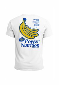 Weißes T-Shirt mit einem Design aus gelben Bananen und blauer Schrift. Der Text beinhaltet "Entfessle Deine Stärke" und "Power Nutrition, Bananengeschmack."