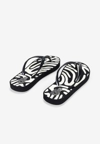 Chanclas negras con una suela a rayas zebra blanca y negra, que presentan tiras delgadas negras. La plantilla muestra un logotipo y la talla "36".