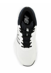 Valkoinen urheilukenkä, jossa on mustia yksityiskohtia, verkkokangasta ja teksturoitu pohja. Varustettu mustilla nauhoilla ja painetulla logolla kielellä.