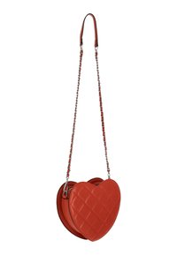 Sac en forme de cœur rouge en cuir matelassé. Dispose d'une bandoulière en chaîne avec des accents en cuir pour le porter, et d'une fermeture éclair.