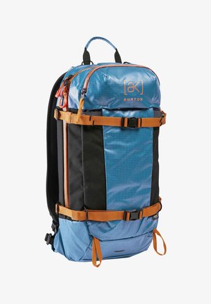Mochila Burton azul y negra con correas y hebillas naranjas, asa superior y varios compartimentos con cremallera.