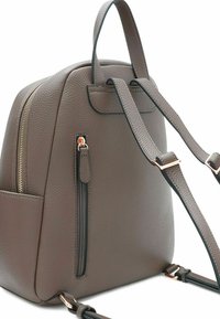 Zaino in finta pelle marrone con texture, spallacci regolabili, tasca frontale con zip e accessori in tonalità oro.