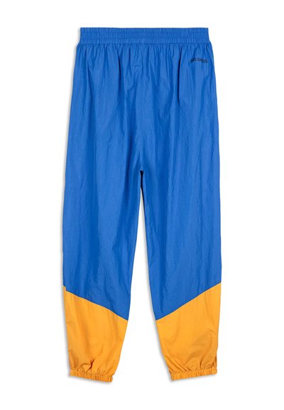 Blauwe en gele windbreaker broek met een elastische tailleband en gathered enkels. De stof heeft een iets gekreukt textuur.