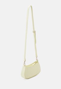 Yellow-green shoulder bag made of textured material, featuring a slim, adjustable strap and a zip closure. The shape is curved and compact.