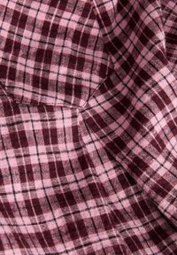 Bomuldsstof med et ternet mønster i bordeaux og lyserød med sorte accenter. Blød tekstur med en diskret glans.